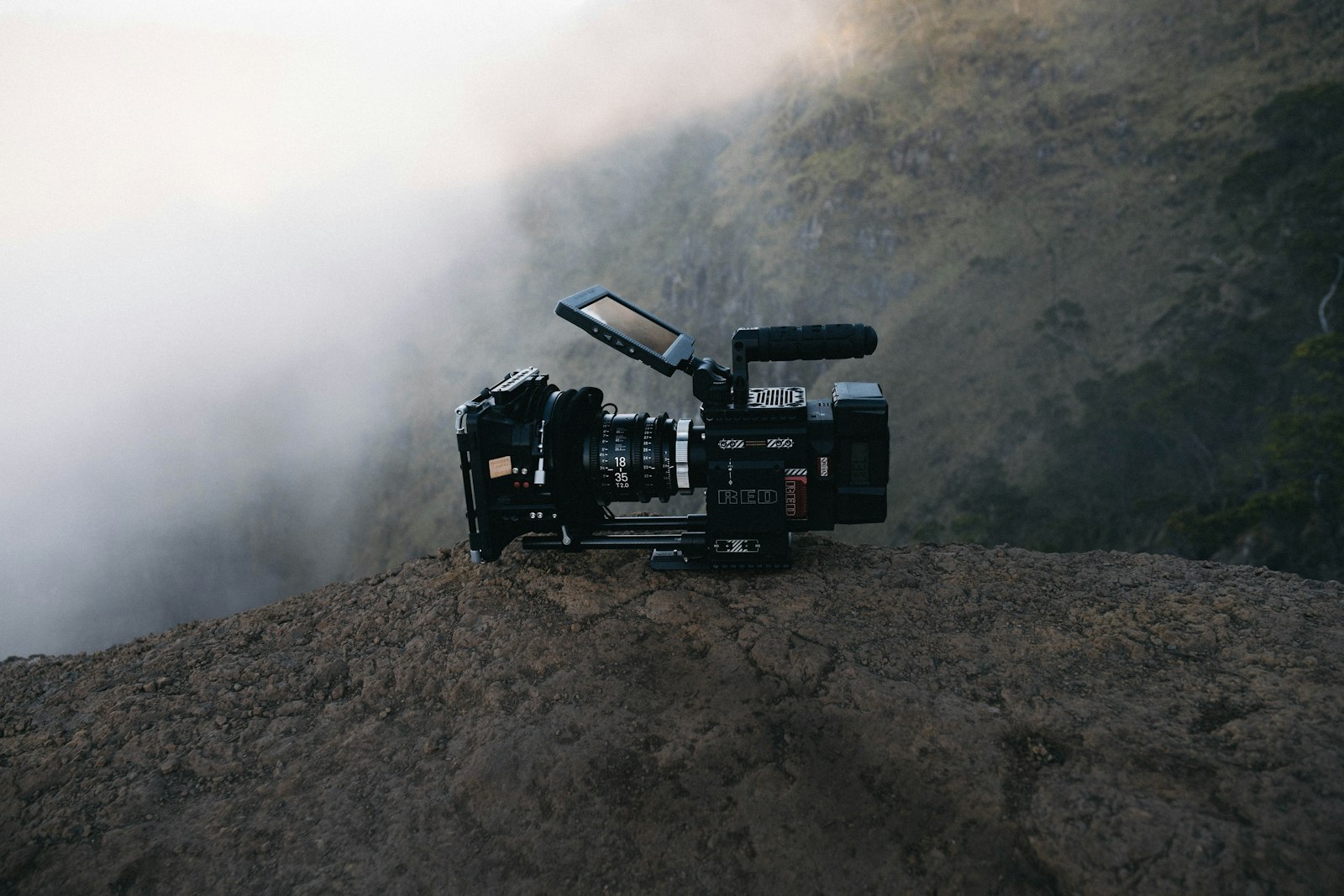 Caméra équipée d'un micro canon posée sur un rocher en extérieur