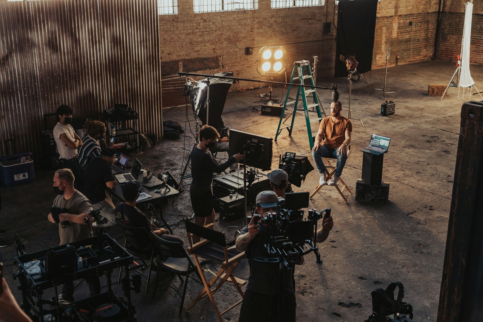 Équipe de tournage installant lumières et caméras autour d'un intervenant
